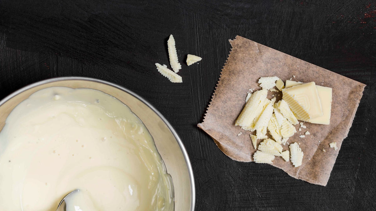 White chocolate mixture with pieces on parchment paper